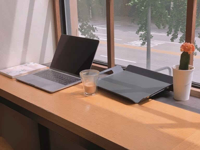 Um Laptop E Um Copo De Agua Sobre Uma Mesa MADezathlZo