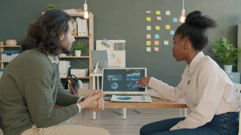 Dois Colegas Discutindo Dados Em Uma Tela De Laptop 1FzEg5g7vt0