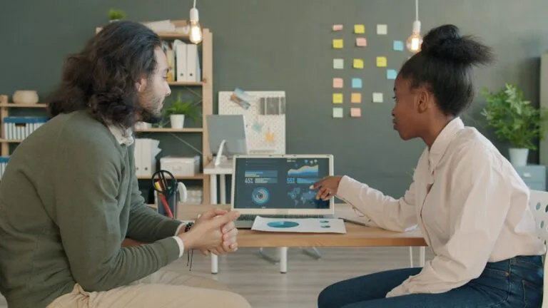 Dois Colegas Discutindo Dados Em Uma Tela De Laptop 1FzEg5g7vt0