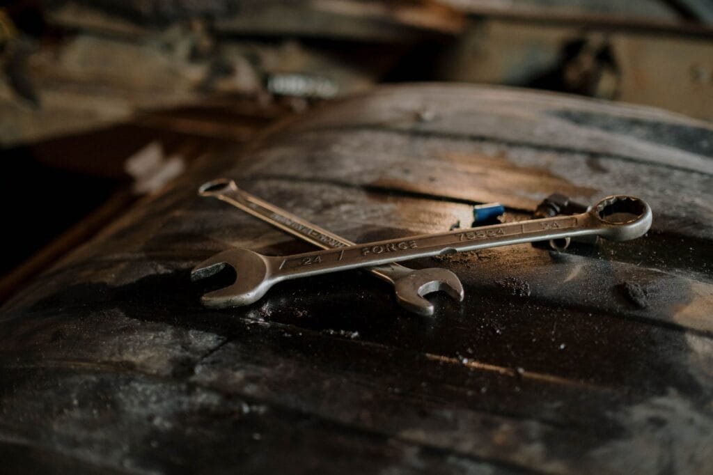 Close-up view of wrenches placed on a textured surface in a workshop setting.