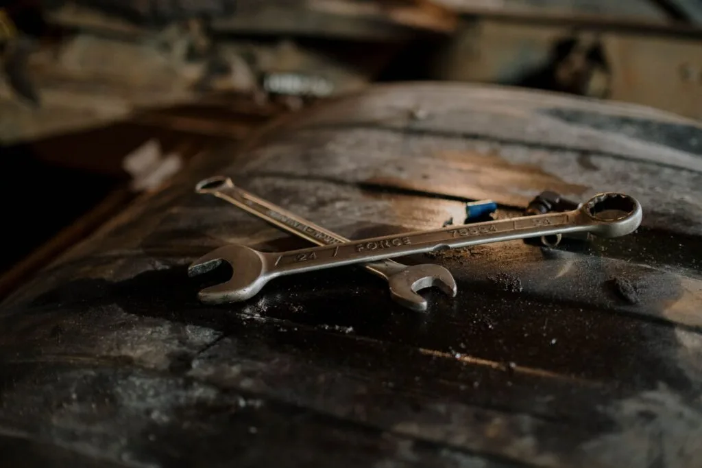 Close-up view of wrenches placed on a textured surface in a workshop setting.