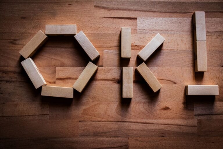 Wooden blocks arranged to spell 'OK' on a wooden tabletop, showcasing creativity in design.